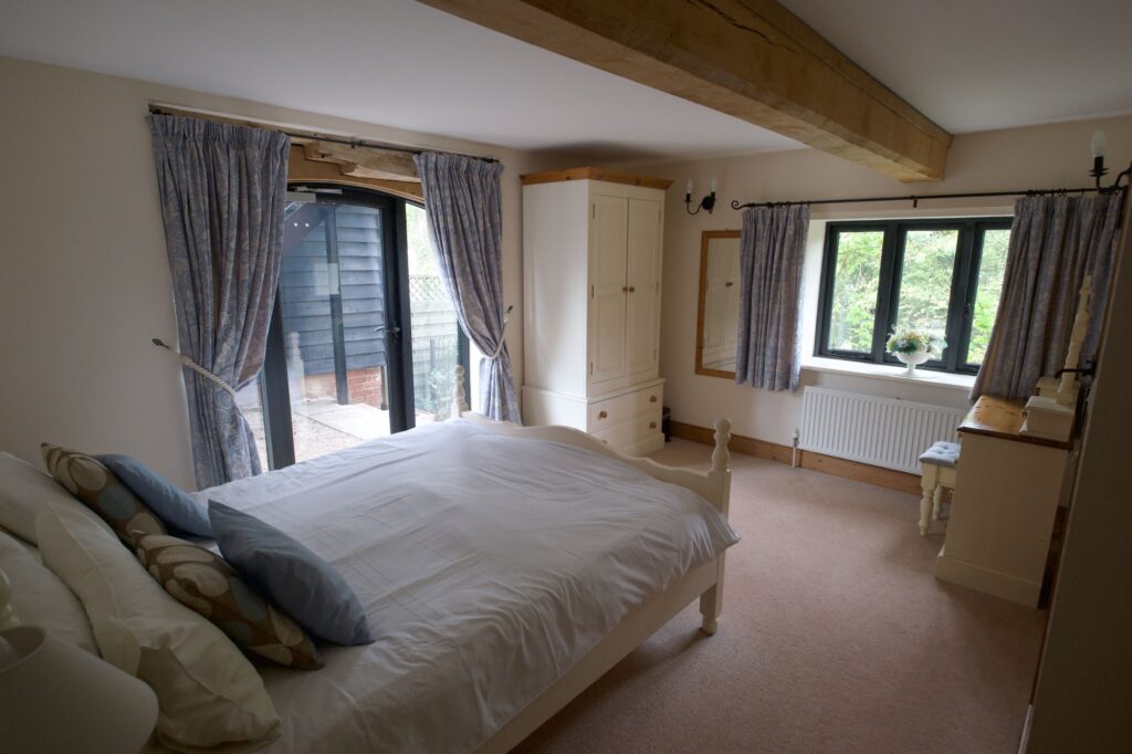 The ground-floor double bedroom with French doors to the courtyard