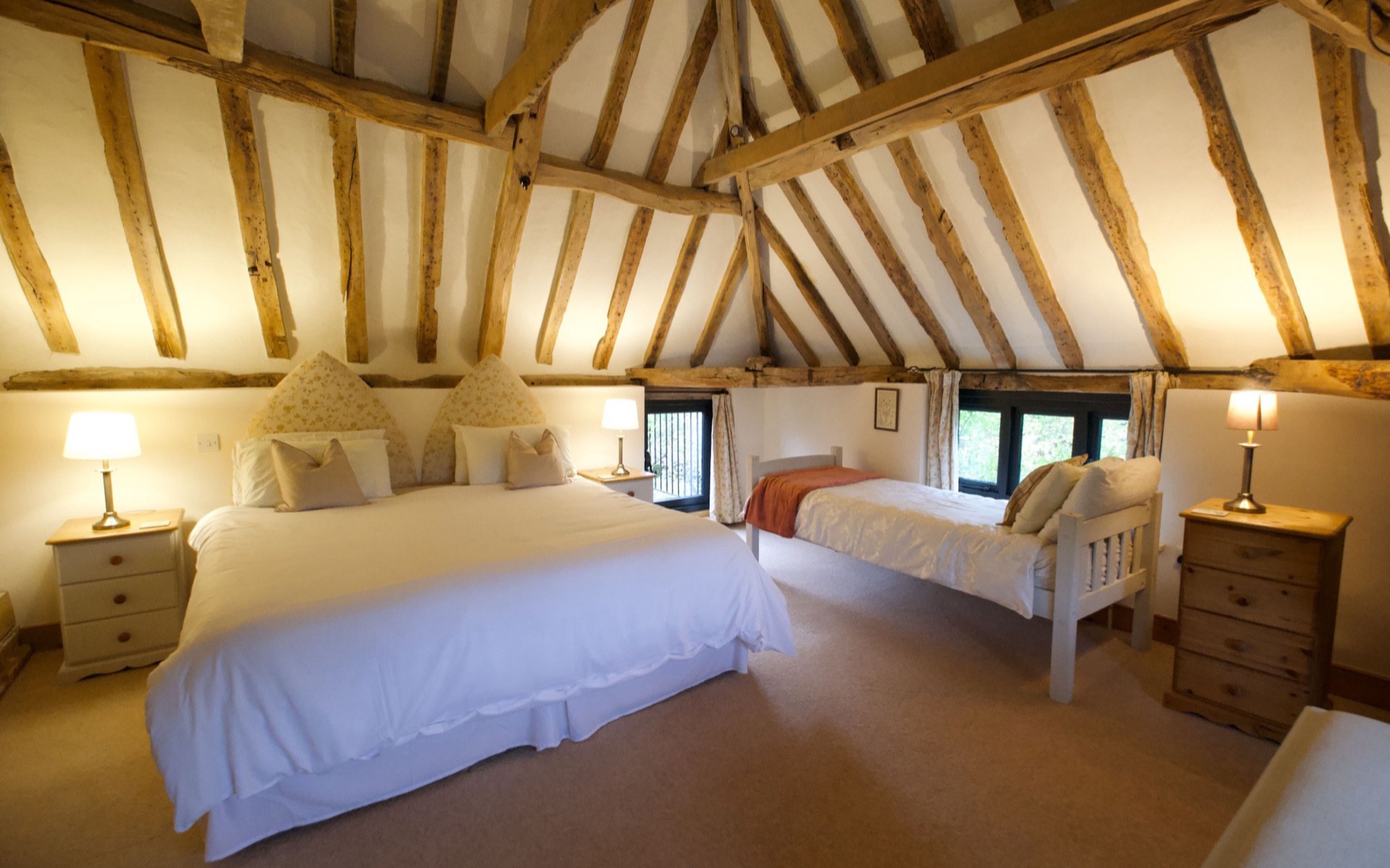 The beamed upstairs bedroom at Owls End with a super king bed and a single day bed