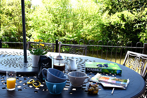 Breakfast and a board game on the patio table, with the moat behind the railings