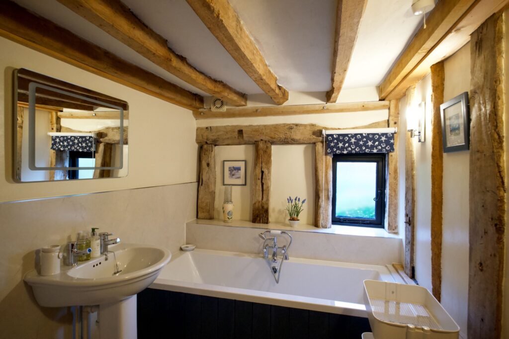 The family bathroom with a bath, basin and exposed oak frame