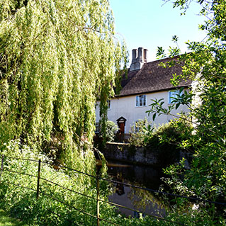 Wattisham Hall seen across the moat, behind a weeping willow