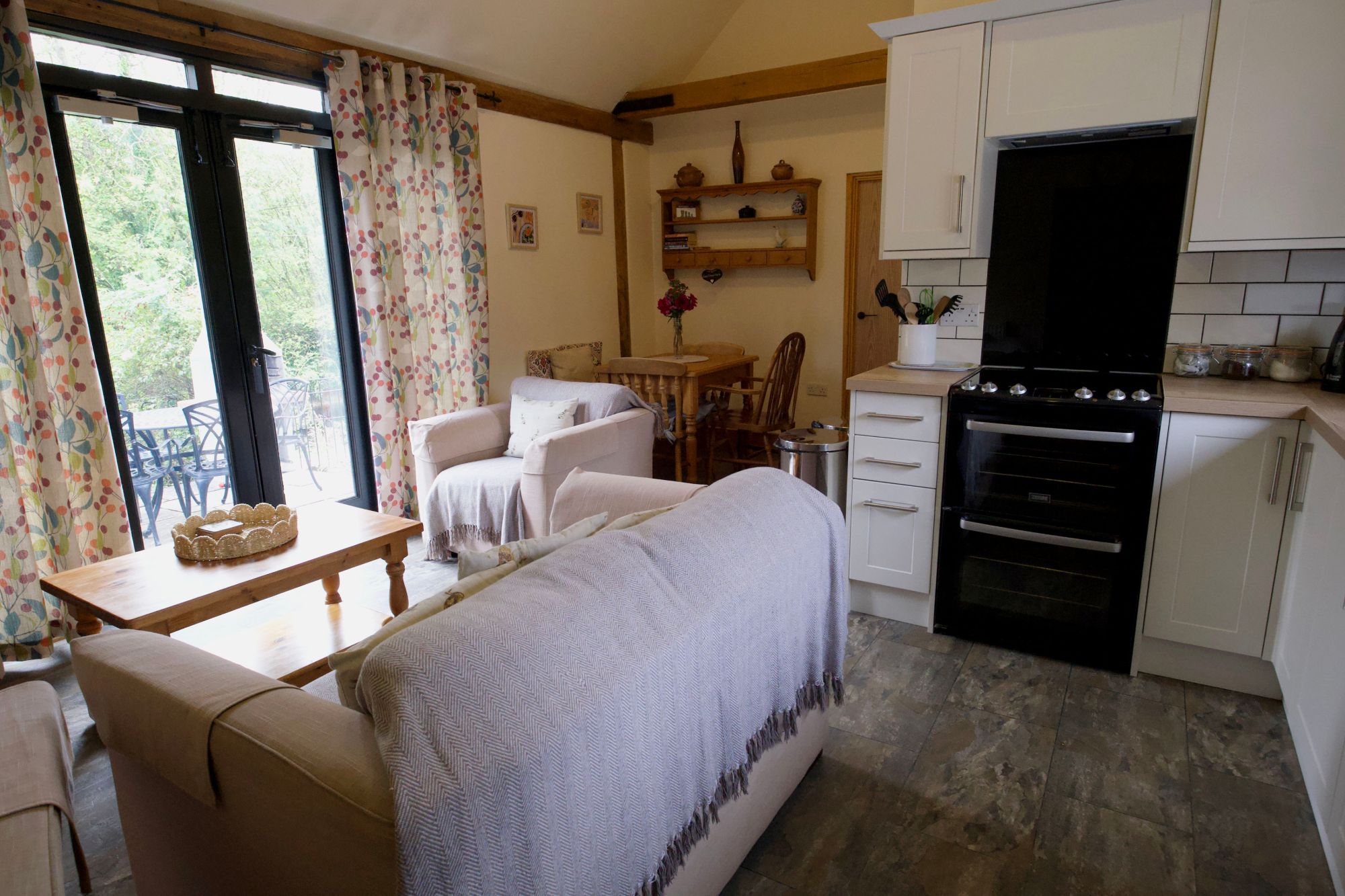 The open-plan sitting room and kitchen at Willow, with French doors to the patio