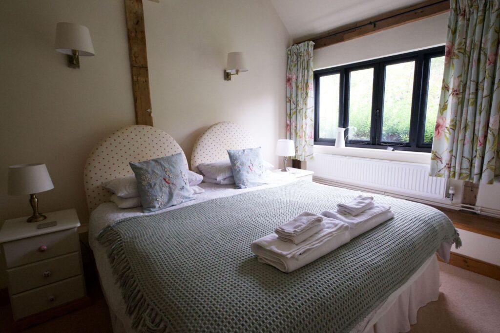 The super king bedroom with two padded headboards and a window onto the garden