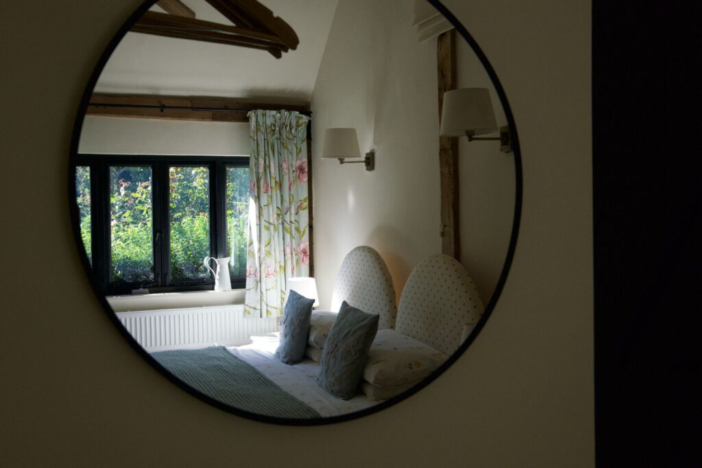 The super king bedroom reflected in a round mirror