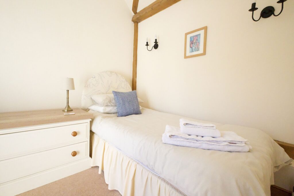 The second single bed in the twin room, with towels laid out